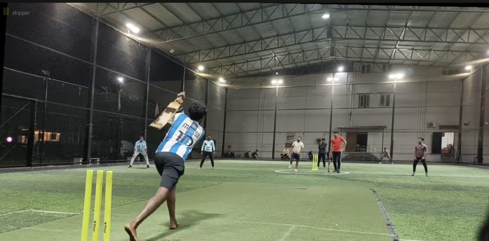 Box cricket match in progress on the enclosed turf arena